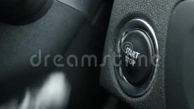 一名女司机按下汽车发动机启停按钮的宏观镜头。